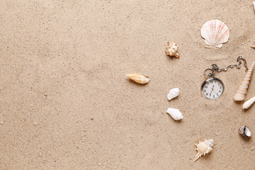 Fototapeta na wymiar Pocket watch and seashells on sand background