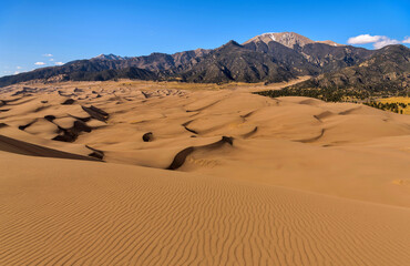 Sand Waves and Ripples - A panoramic Spring evening view of rolling sand dune waves and pristine sand ripples at base of Mt. Herard. Great Sand Dunes National Park, Colorado, USA.