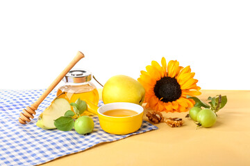 Composition with sweet honey, apples and sunflower on color table against white background