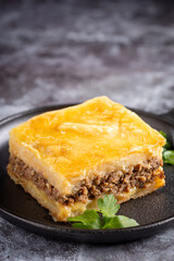 Piece of shepherd's pie on dark plate.