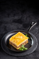 Piece of shepherd's pie on dark plate.