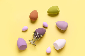 Different makeup sponges on yellow background