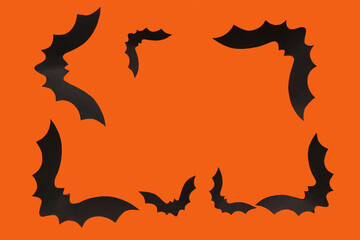 Frame made of paper bats for Halloween party on orange background