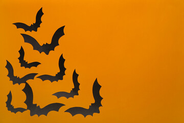 Paper bats for Halloween party on orange background
