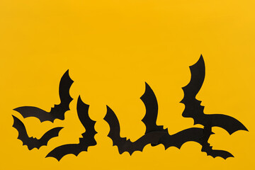 Paper bats for Halloween party on yellow background