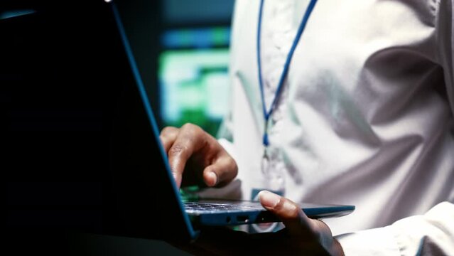 Extreme close up shot of experienced IT programmer using laptop to audit high tech facility security to protect information access, making sure virus protection software is updated
