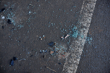 vidros quebrados no asfalto, vestigios de acidente de carro 