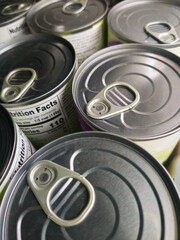 Tin metal cans with pull tab pop top openers top view photo. Canned food on shelf of grocery store,...