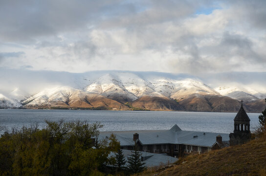 Vaskenian Theological Academy, seminary of the Armenian Apostolic Church on the shores of Lake Sevan with snow capped mountains in distance in Armenia