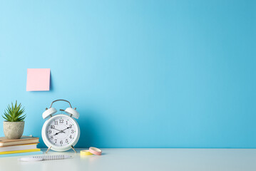Showcase productivity in a student's workspace through a side-angle photograph of a white desk, alarm clock, notepads and stationery on a blue isolated background, ideal for text or adverts - Powered by Adobe