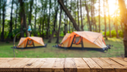 Wooden table background of free space for your decoration and blurred background of camping in...