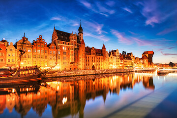 Fototapeta na wymiar Illuminated Gdansk Old Town with Calm Motlawa River at Dusk, Poland