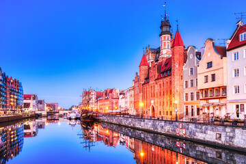 Fototapeta premium Illuminated Gdansk Old Town with Calm Motlawa River at Dusk, Poland, Poland