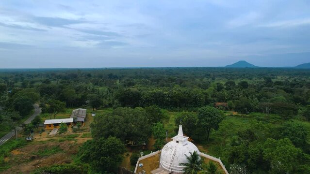 Aerial drone flying above the beautiful village with views of the Temple Buddhist Stupa Sri Lanka. Aerial view of the pagoda. Zoom in Footage by drone.