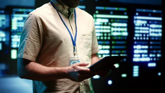 Experienced engineer inspecting operational server racks in computer network security data center. Supercomputers providing processing and memory resources for different workloads