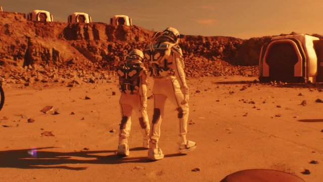 Two astronauts in spacesuits walk toward research station, colony or scientific base on Mars. AI powered rover rides in the background. Space mission. Futuristic colonization and exploration concept.