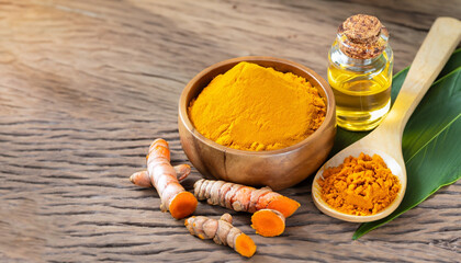 Tumeric (curcumin, curcuma longa Linn) powder in wooden bowl and spoon with root and bottle of...