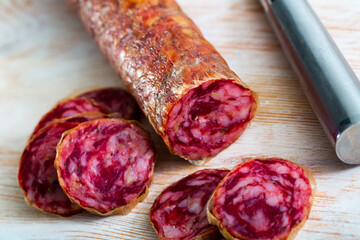 Obraz premium Appetizing salchichon sausage on wooden table. High quality photo