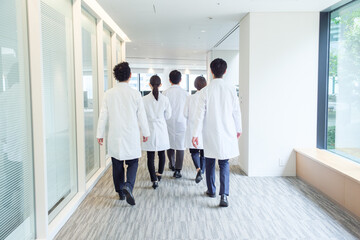 病院を歩く医師の背中