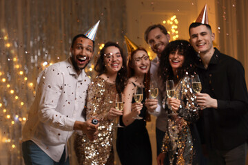Blurred view of happy friends with glasses of sparkling wine celebrating birthday indoors