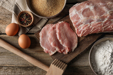 Different ingredients for cooking schnitzel on wooden table, flat lay