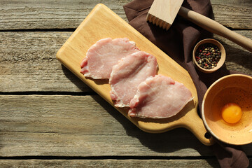 Different ingredients for cooking schnitzel on wooden table, flat lay. Space for text