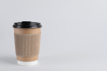 Paper cup with plastic lid on light background, space for text. Coffee to go