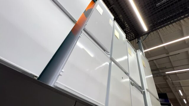 New refrigerators lined up in a home appliance store. Extreme wide low angle view