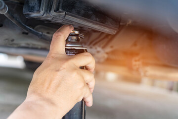 Basic vehicle inspection and maintenance, Close up hand a man holding anti-rust paint spraying car undercarriage to prevent rust, Car good protection and service concept by myself