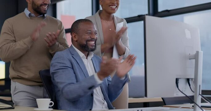 Clapping hands, celebration and business people in the office by a computer for teamwork success. Diversity, good news and group of professional corporate lawyers cheering by technology in workplace.