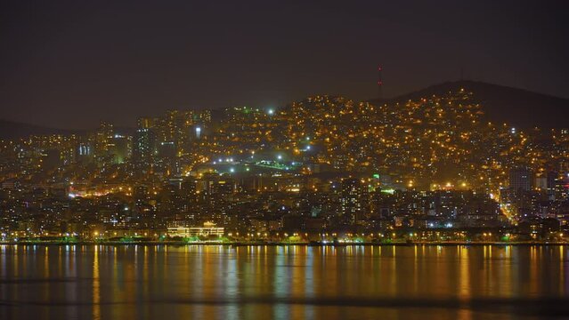 Timelapse: view of city of Istanbul from the Princes Islands at night. Apartment, residential buildings with blinking illuminated windows with reflection in the water - time lapse, cityscape