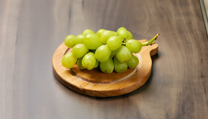 A small bunch of green grapes on a small round wooden serving board