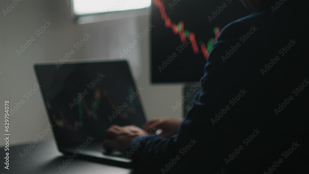 Fototapete Back view of stock market broker in analyzing data and graphs on multiple computer screens while sitting in modern office.