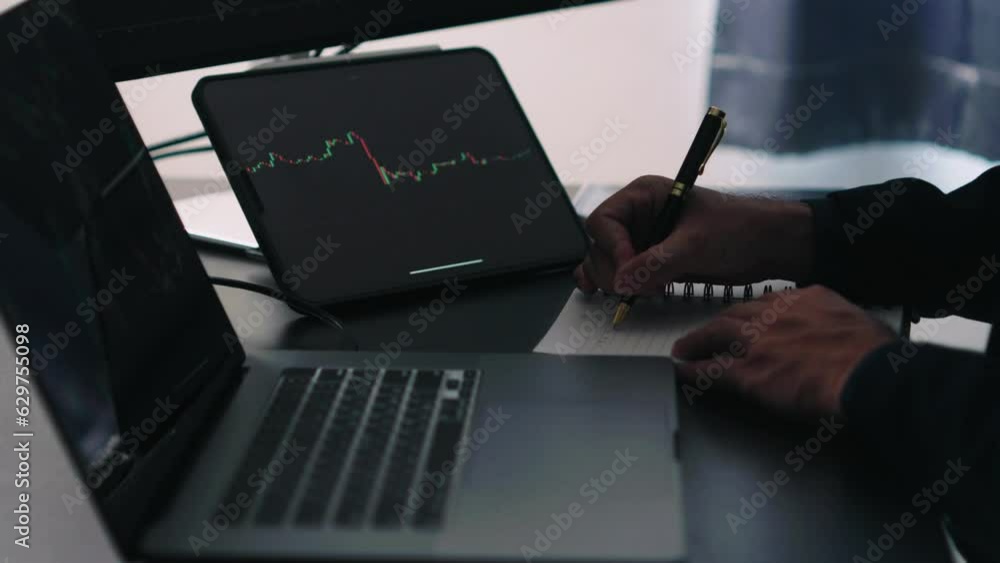 Poster Back view of stock market broker in analyzing data and graphs on multiple computer screens while sitting in modern office.