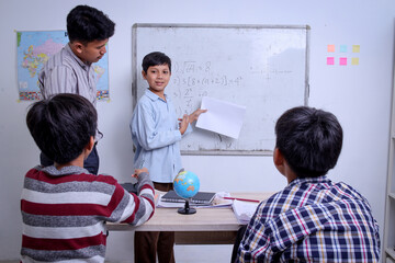 Schoolboy Asian student presenting project to friends and teacher during class lesson at school