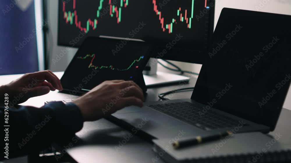 Poster Back view of stock market broker in analyzing data and graphs on multiple computer screens while sitting in modern office.