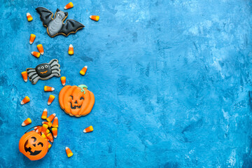 Basket with tasty Halloween candy corns and cookies on blue background