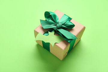 Beautiful gift box and bat made of paper for Halloween on green background, closeup