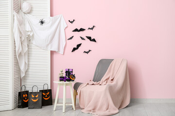 Interior of modern living room decorated for Halloween with chair, folding screen and table