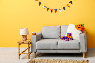 Interior of modern living room decorated for Halloween with sofa, lamp and table