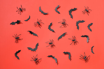 Paper bats and spiders for Halloween party on red background