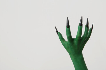 Green hand of witch on white background. Halloween celebration