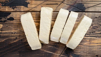 Slices of raw tofu on shabby wooden background. Top view