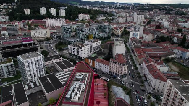 Revealing drone shot of Saint Etienne city in Loire Departement with design building and nature