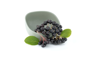 Aronia berries with a green leaf isolated on white