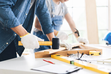 Closeup carpenter hand wearing gloves using hamme with child in workshop