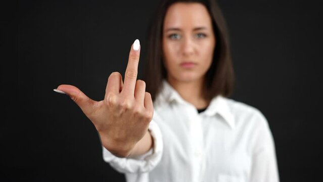 Young Woman Showing Middle Finger Gesture in Front of Camera, Studio Shot
