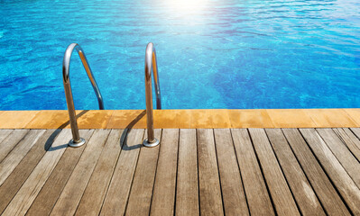 Swimming pool with stainless steel ladder stairs and wooden deck
