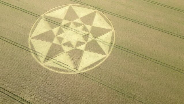 Rotating aerial view looking down over Micheldever geometric crop circle formed on rural Hampshire wheat farmland