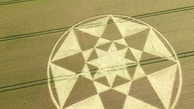 Aerial view descending towards Micheldever 2023 star shaped crop circle formation on golden Hampshire wheat field